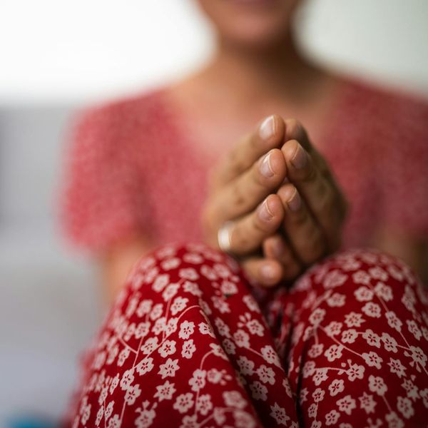 A person meditating peacefully with a serene natural background.